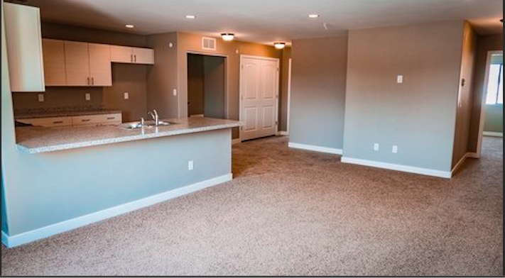 large living space off kitchen furnished with barstools, couch and flat screen TV - 1043 North Ave