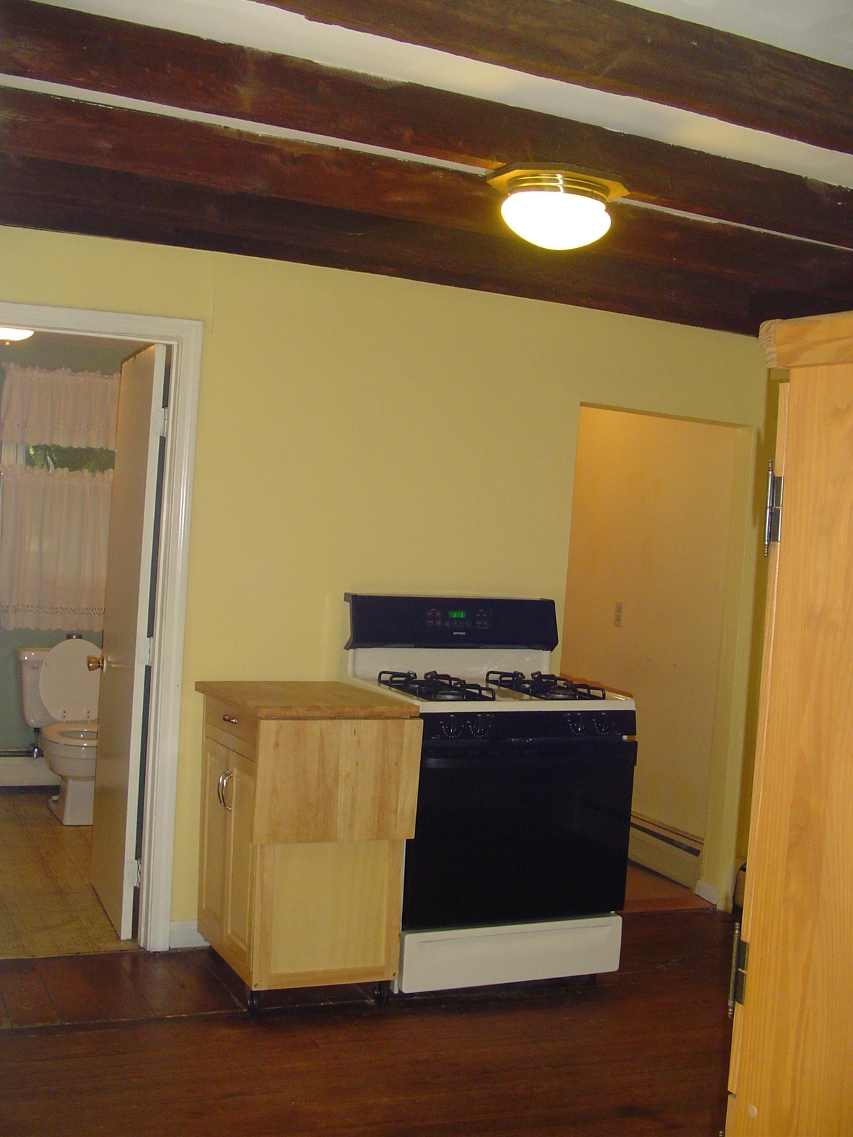 Kitchen stove, bathroom on left, laundry room on right - 165 Nonotuck St