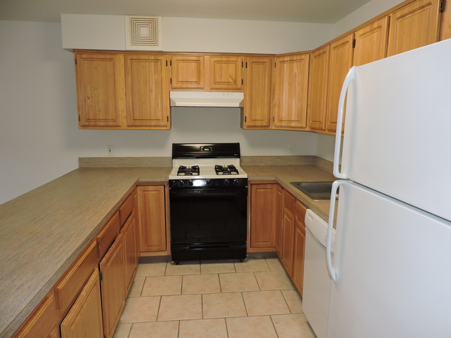 Kitchen With Wooden Cabinets - Shore View Apartments