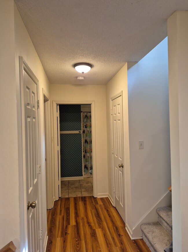 downstairs hallway with coat closet (left), storage closet (right), and bathroom - 4422 Beechnut Ln