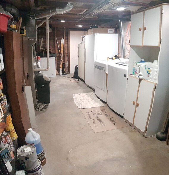 Basement laundry area with plenty of storage space and an extra room at the far end of the picture to another large closet. - 407 S. 6th Street