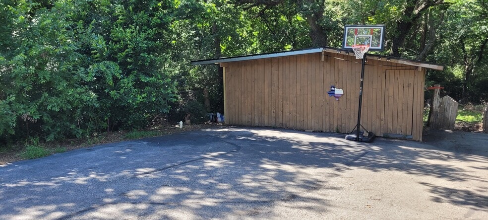 View of barn, basketball court, and woods. - 125 Woodland Dr
