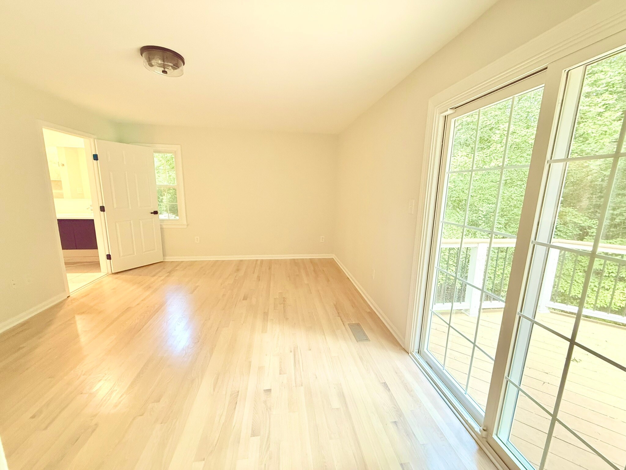 Main floor primary with doors leading to deck - 9248 Wood Glade Dr