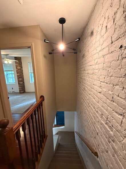 Modern chandelier at the top of the brick stairs adds style - 327 Hudson Ave