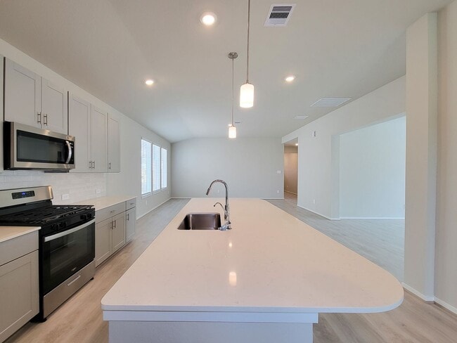 Building Photo - Single-story layout features a bright, open concept living area, dining space, and kitchen. Pebbl...