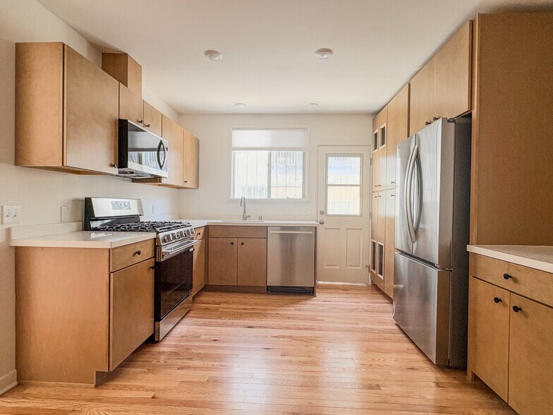 Kitchen with brand new stainless steel appliances, quartz countertops, and maple cabinets - 1041 Wilcox Ave