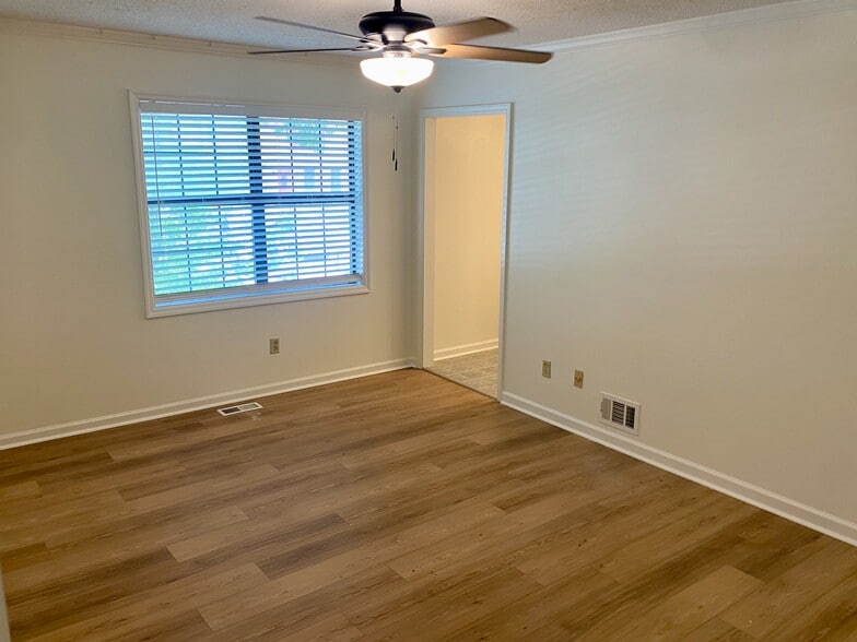 Bedroom 2 with picture window looking to the shady street and front yard. - 7005 Sand Wedge Cir