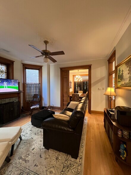 Second living room with additional fireplace, original woodwork, and floors - 938 W Newport Ave