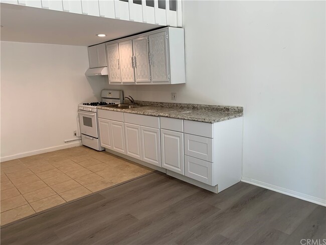 Kitchen w/ gas stove & cabinetry - 5820 Calvin Ave