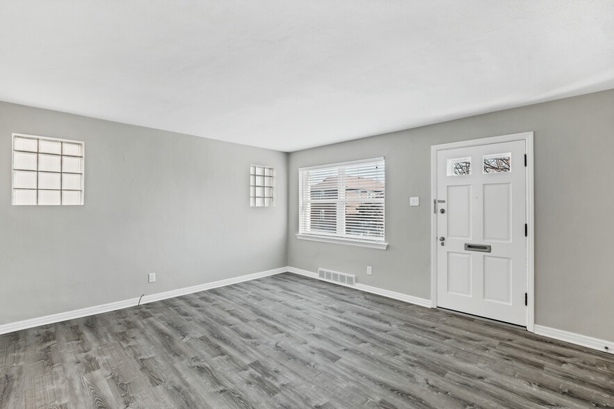 Living room feature wall is perfect for TV Console or add an electric fireplace/TV stand between the glass block windows. - 3443 Lawn Ave