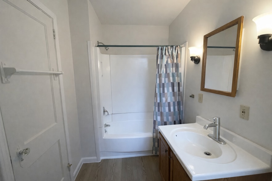 Bathroom with full size shower/bath and ample storage. - 513 1/2 W James St