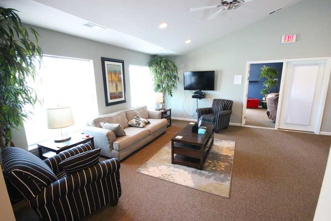 A beautiful lounge in the clubhouse is sunny and welcoming! - Cottages at Sheek Road Apartments