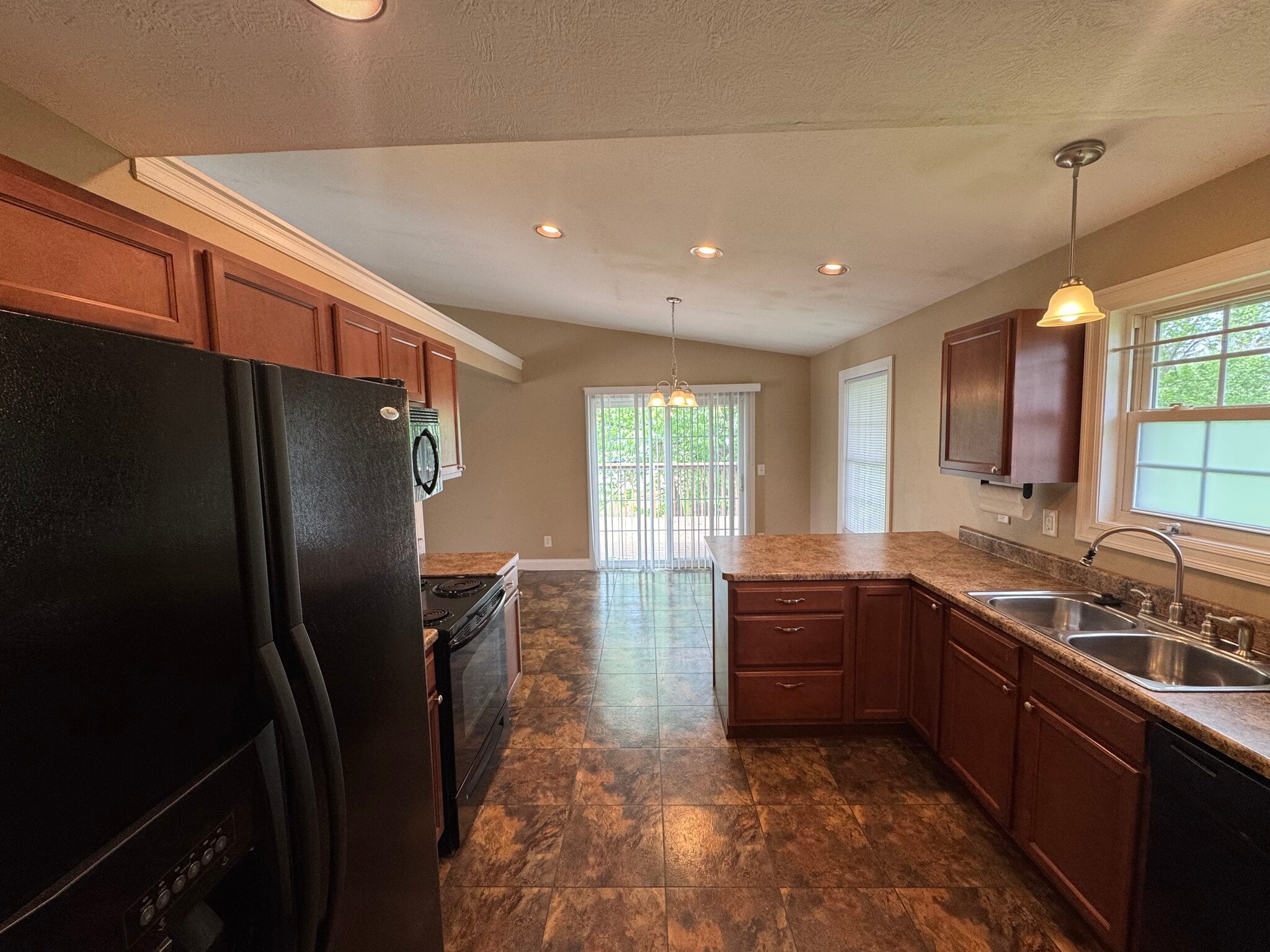 Fully equipped kitchen with counter bar and sliding patio doors leading to private deck. - 1343 Easy St