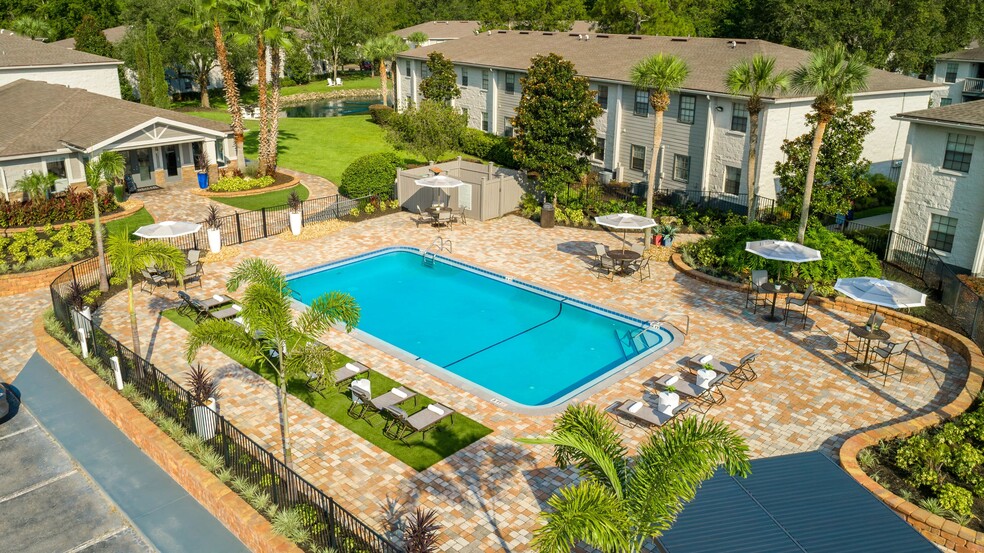 Lounge in luxury on our expansive sundeck, surrounded by lush palm trees and elegant poolside seating. - Ridgemar Commons