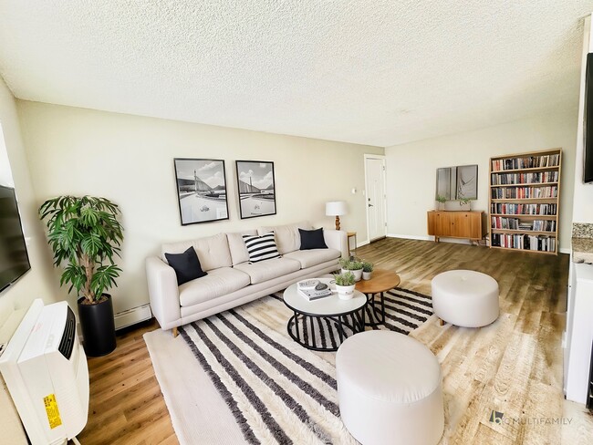 Experience relaxation in this stylish and inviting living room, perfect for unwinding. - Hawk Point Apartments