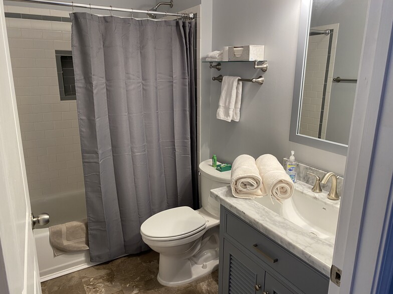 sleek bathroom with subway tile and marble top vanity - 735 Walker Square