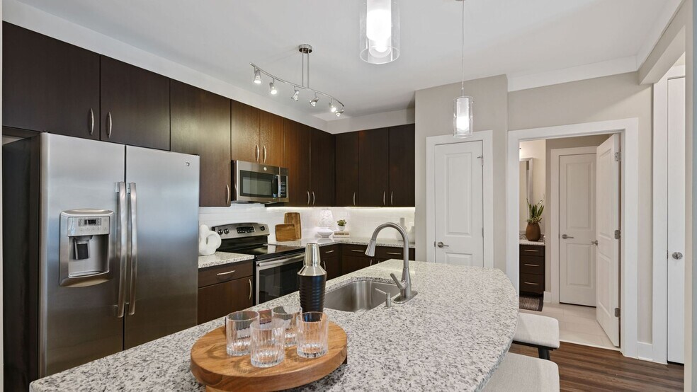 Kitchens with granite counters, subway tile backsplash and side-by-side stainless steel refrigerator with exterior ice/water dispenser - Marshall Park Apartments + Townhomes