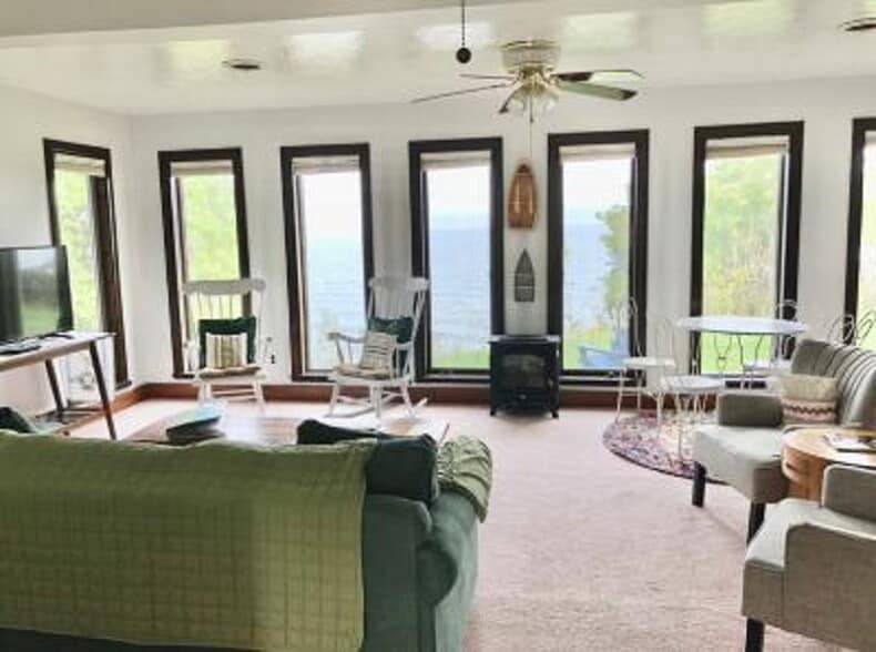 Spacious living room with windows overlooking the lake - 3061 Maple Ave