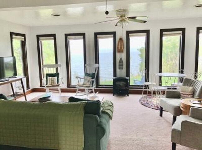 Spacious living room with windows overlooking the lake - 3061 Maple Ave