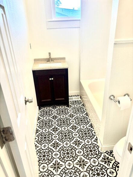 Main, full bath with new vanity, toilet, flooring, full tub, 10ft ceiling, fan, fresh paint! - 601 J Street