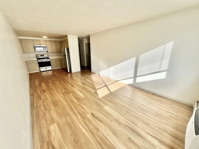 Experience cooking in a sunlit, modern kitchen with sleek finishes. - Harmony Apartments