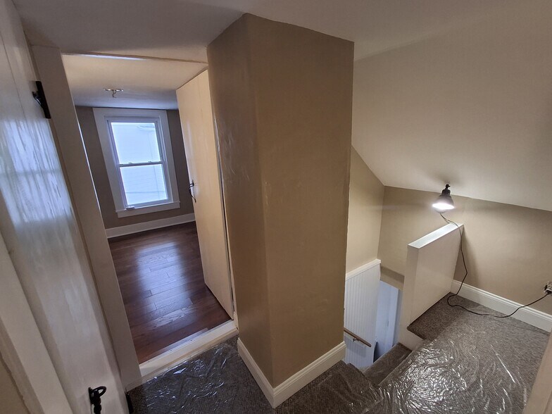 3rd floor hallway, new carpeting; this photo faces bedroom 3. Storage space between rooms. - 13 Mulberry St
