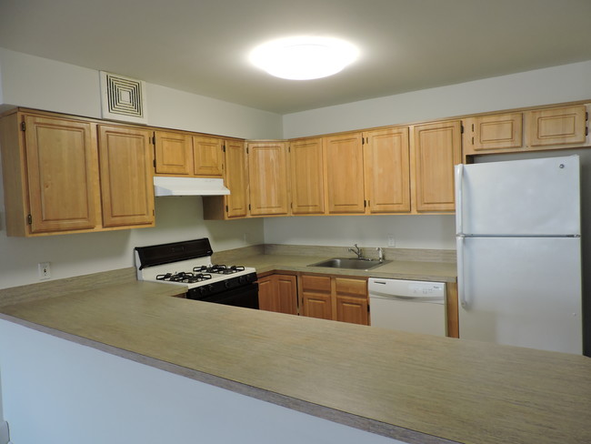 Kitchen With Wooden Cabinets - Shore View Apartments