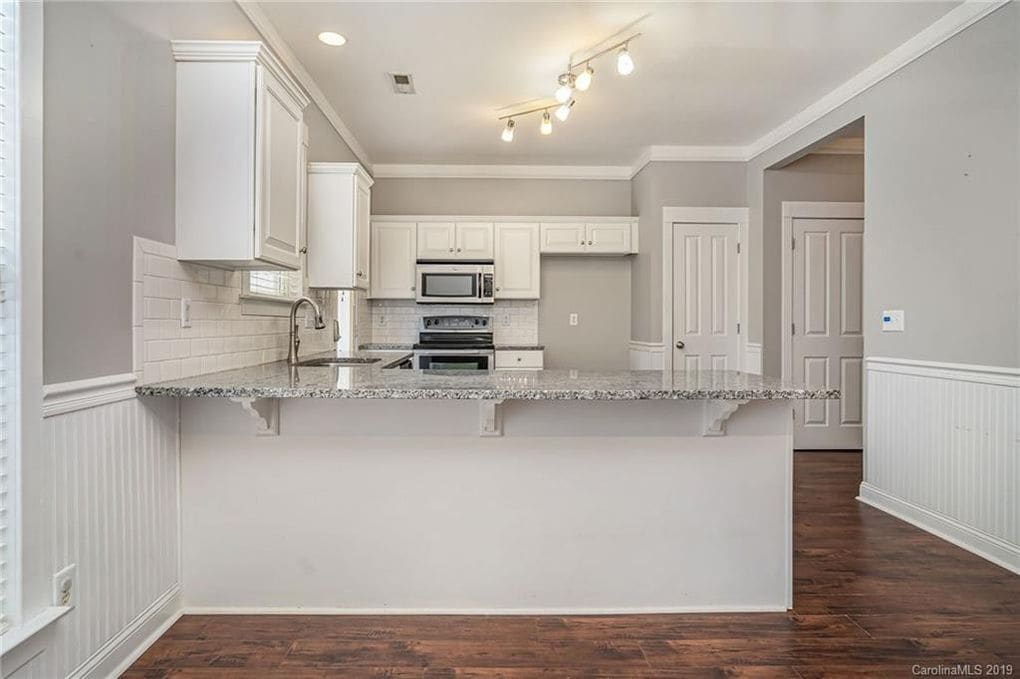 Kitchen with granite counter tops, white subway tile backsplash, stainless steel appliances, brand new fridge and breakfast bar. - 11323 Deer Ridge Ln