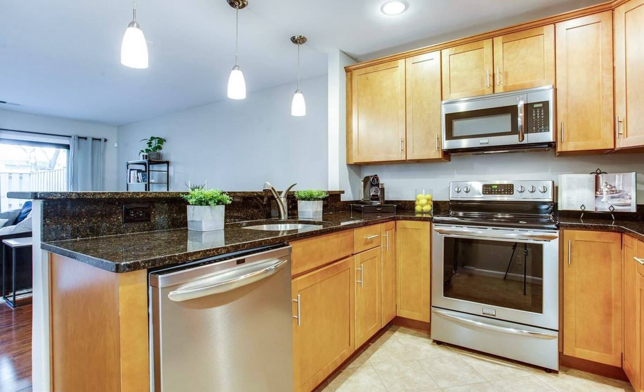 Kitchen with Granite Countertops and Pendant Lighting above the Breakfast Bar - 2681 Glengyle Dr