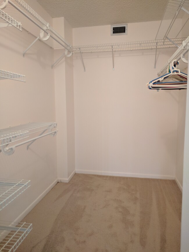 Large walk in closet with multi-level shelves, racks, and hanger bars. - 198 NW 67th St