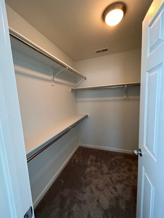 Primary bedroom walk-in closet - 9921 E 26th Ave