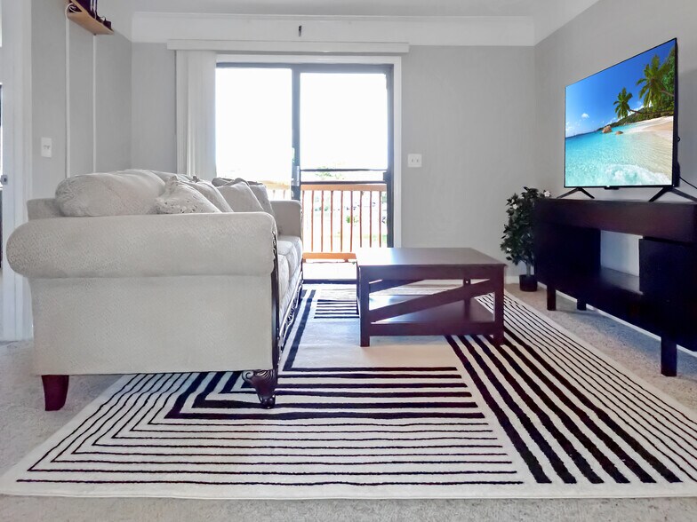 Living room includes new furniture, 55" Roku TV, south-facing patio. - 3601 Saint Johns Ct