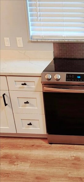 Close-up kitchen view highlights detailed cabinetry, modern hardware, and sleek stainless range. - 21 Richmond Sq