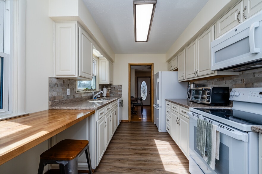Cook with ease in this clean, sunlit kitchen featuring ample counter space, modern appliances. - 2767 Oakwood Ln