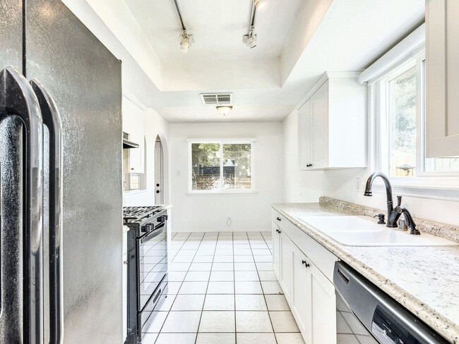 Building Photo - Charming 4BR / 2BA Home Featuring Fireplace, White Cabinets & Big Tree