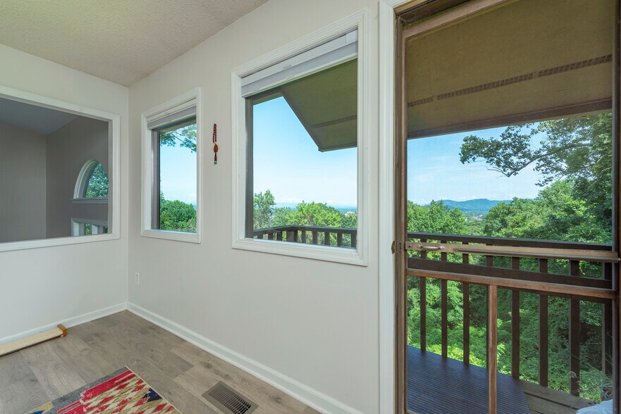 Exclusive master bedroom area leading out to a peaceful, private balcony overlooking treetops. - 405 Windswept Dr