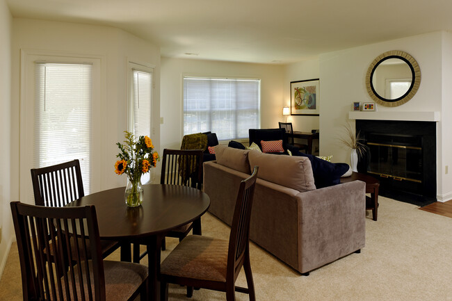 Carpeted dining and living area with fireplace - eaves Fairfax City