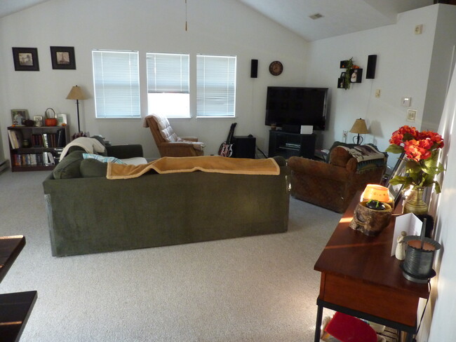 Great room with vaulted ceiling, carpeting throughout interior. (Furnishings viewed are not provided) - 1413 Loop Road