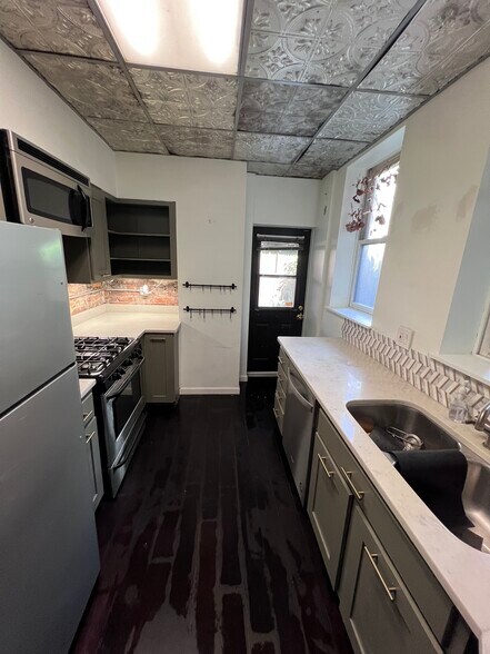 First floor: Kitchen (gas stove, microwave, granite countertops, double-bowl sink, garbage disposal) - 103 S 22nd St