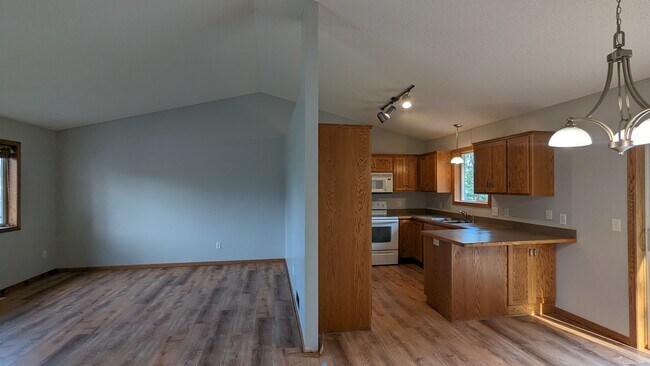 Open living/dining spaces adjacent to the kitchen. - 758 Park Brook Rd NW