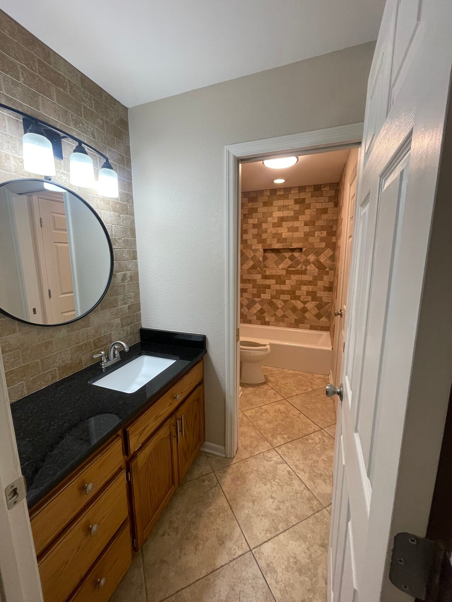 Full bath has tub shower with tiled tub surround and cast iron tub - 5191 County Road 73