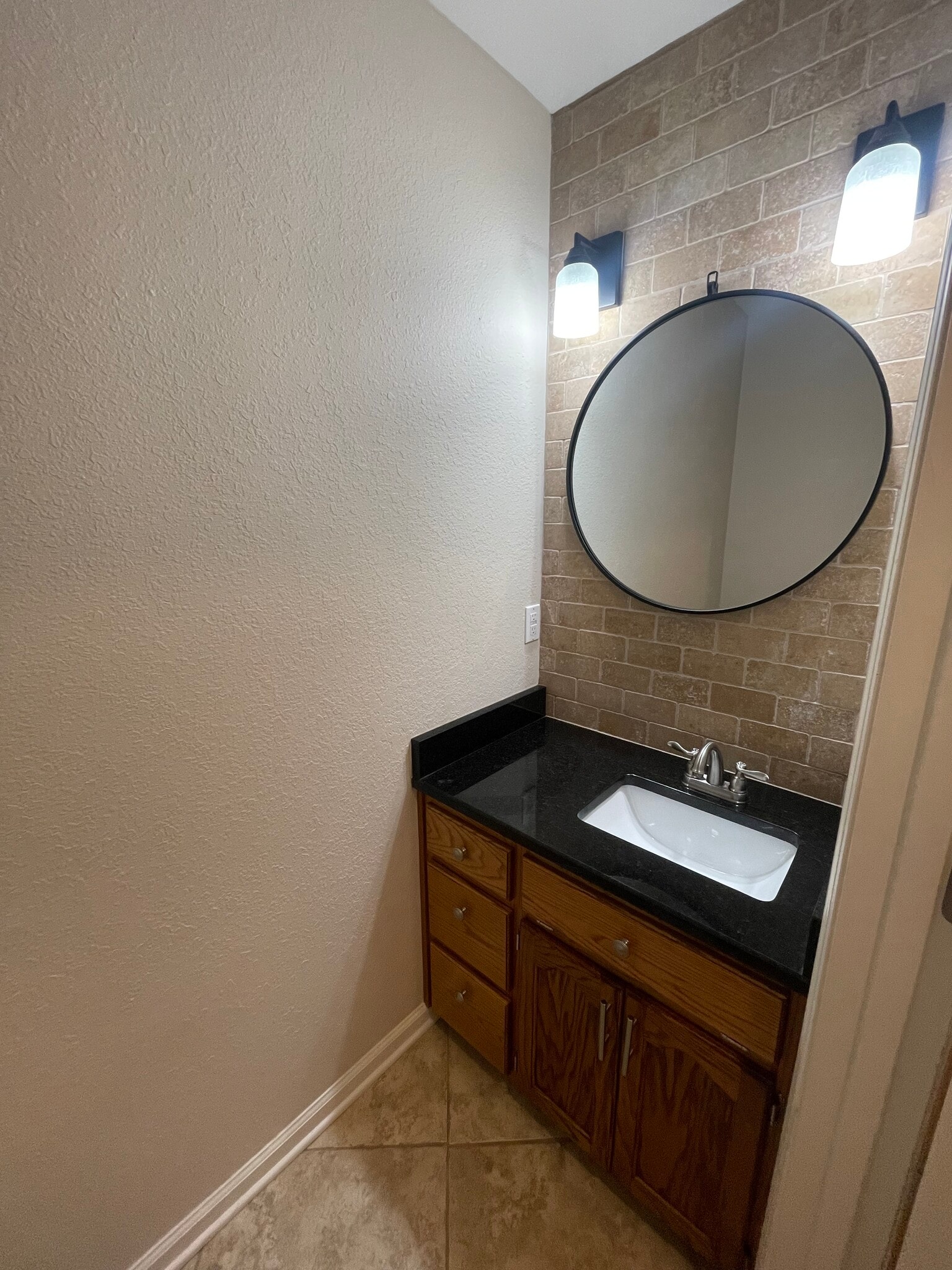 Half bath has granite countertops and tiled vanity wall - 5191 County Road 73