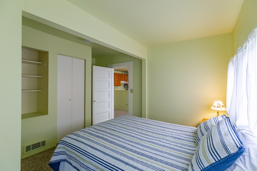 Queen size bed with four pillows. - 703 Q Ave Apt 4