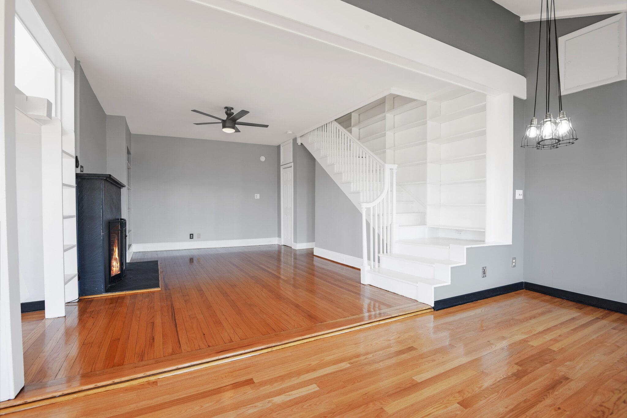 living room with stairs to nowhere and shelving - 1301 Rogers Rd