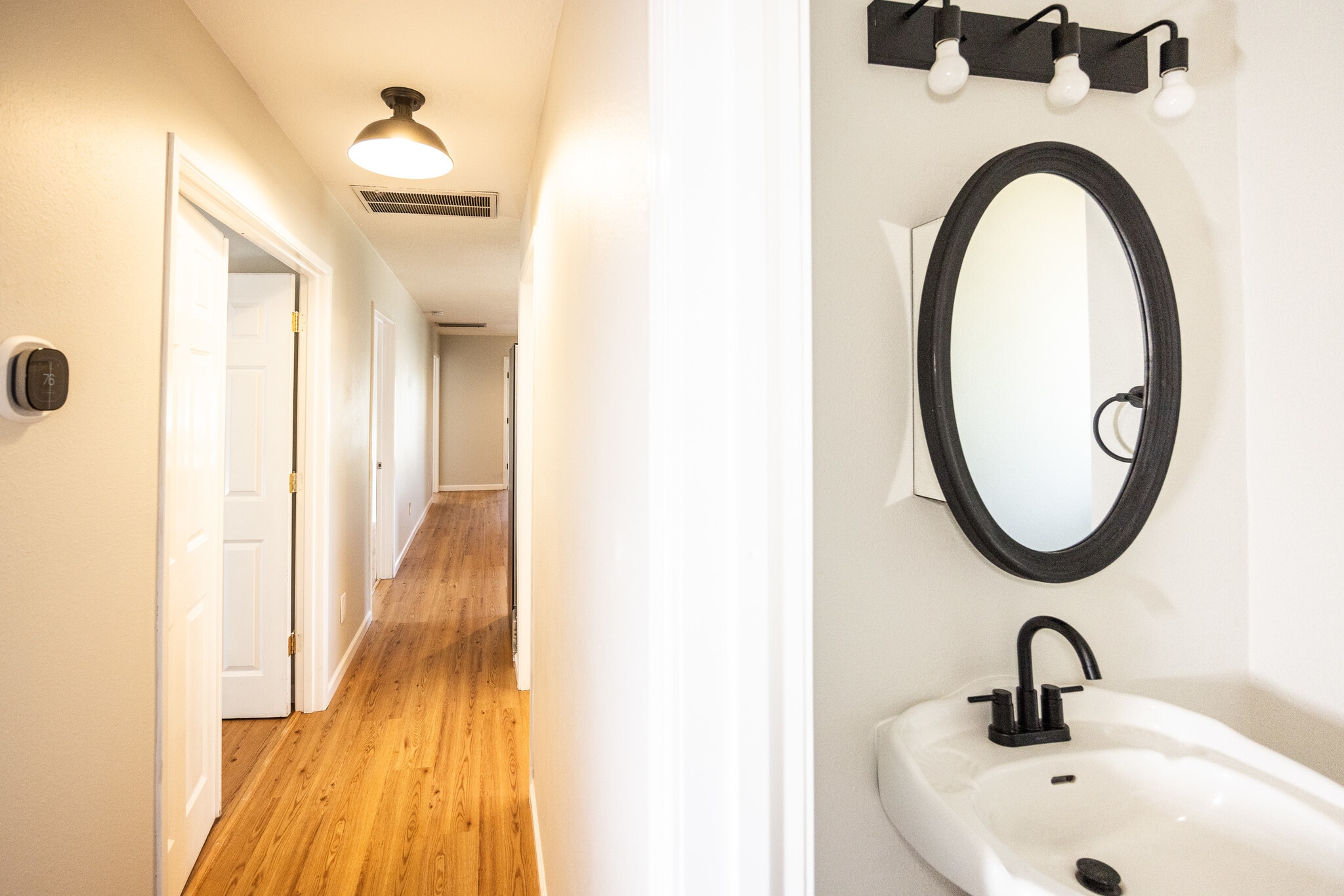 Walking out of half bath down hallway towards bedrooms/living space - 8717 NE Webster St