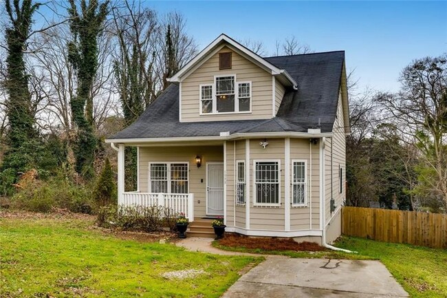 Front yard with a porch and driveway for parking. - 1999 Meador Ave SE