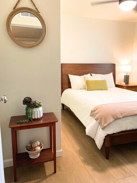 Bedroom 2 with a nightstand, lamp, blackout wood blinds, darkening curtains and a closet. - 1795 W 28th St