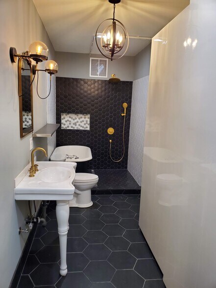 Bathroom with separate shower and antique claw-foot tub. French-style sink, recessed lighting and signature light fixtures - 579 W. 13th St