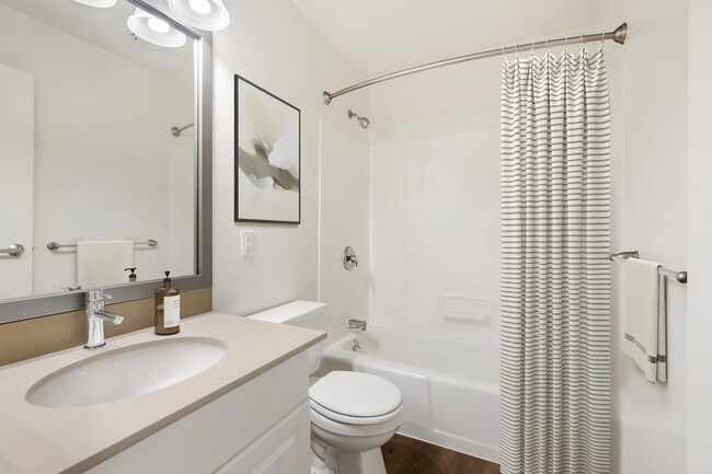 Renovated Package III bath with grey quartz countertops, white or cherry cabinetry, and hard surface flooring - eaves Quincy