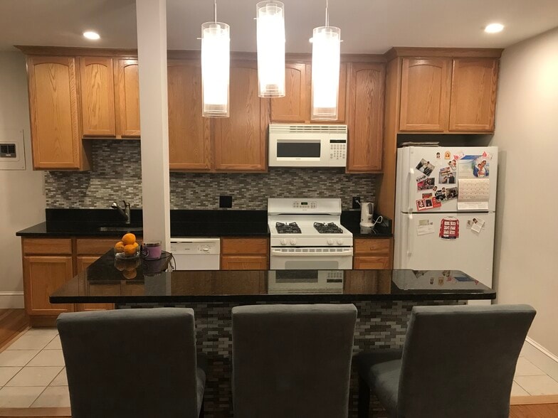 Open floor plan- furnished kitchen with cookware and silverware, furnished island with bar stools - 3719 12th St NE